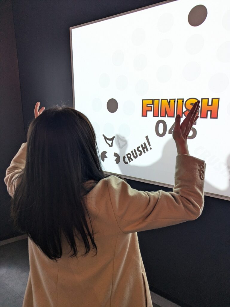 Pessoa utilizando a própria sombra para jogar Game & Watch SP no Nintendo Museum.