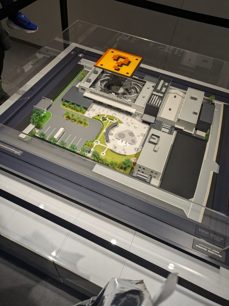 Maquete detalhada do complexo do Nintendo Museum com bloco de interrogação no topo.